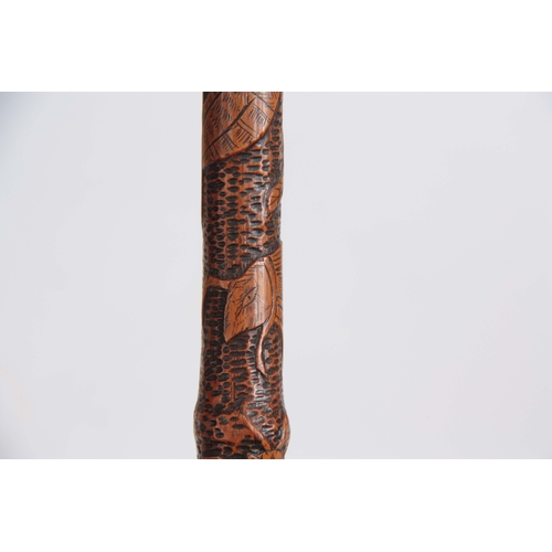 450 - A 19th CENTURY JAPANESE BAMBOO WALKING CANE having a root handle, the stick carved all over with var... 