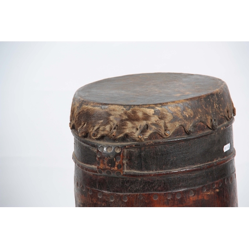 506 - A 19TH CENTURY AFRICAN DRUM with goats skin top on a hollowed trunk wooden base 103cm high.