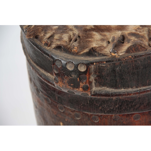 506 - A 19TH CENTURY AFRICAN DRUM with goats skin top on a hollowed trunk wooden base 103cm high.