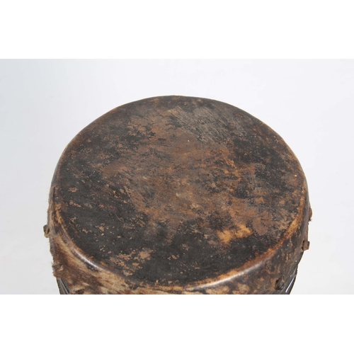 506 - A 19TH CENTURY AFRICAN DRUM with goats skin top on a hollowed trunk wooden base 103cm high.