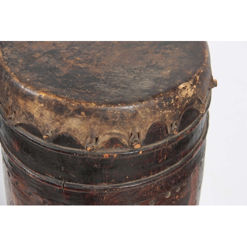 506 - A 19TH CENTURY AFRICAN DRUM with goats skin top on a hollowed trunk wooden base 103cm high.