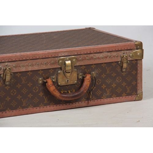 519 - A VINTAGE LOUIS VUITTON BROWN LEATHER SUITCASE with studded brass corner mounts and angle straps to ... 