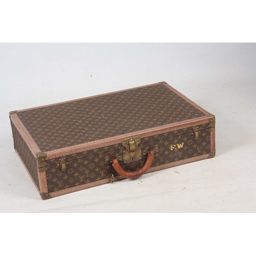 520 - A VINTAGE LOUIS VUITTON BROWN LEATHER SUITCASE with studded brass corner mounts, fasteners and lock ... 