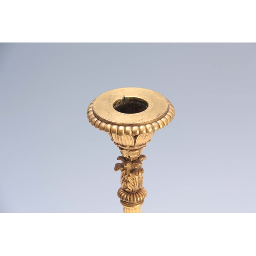 606 - A 19TH CENTURY FRENCH EMPIRE STYLE GILT BRASS CANDLESTICK with tapering reeded stem and leaf cast sc... 