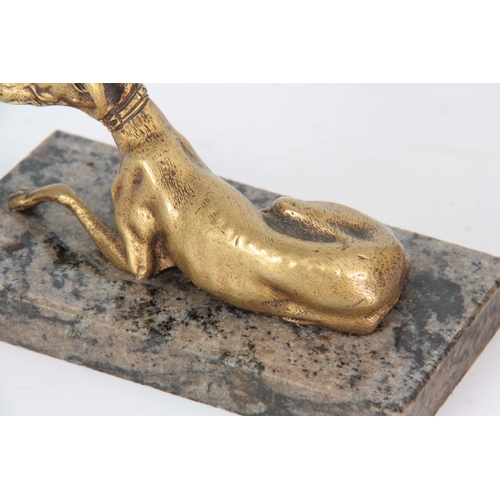 627 - AN EARLY 20th CENTURY GILT BRONZE SCULPTURE modelled as a recumbent greyhound mounted on a marble ba... 