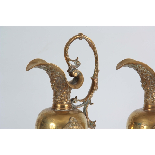 630 - A PAIR OF LATE 19TH CENTURY BRONZE EWERS having shaped spouts and leaf cast handles, with applied re... 