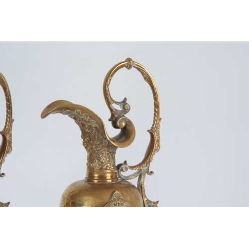 630 - A PAIR OF LATE 19TH CENTURY BRONZE EWERS having shaped spouts and leaf cast handles, with applied re... 