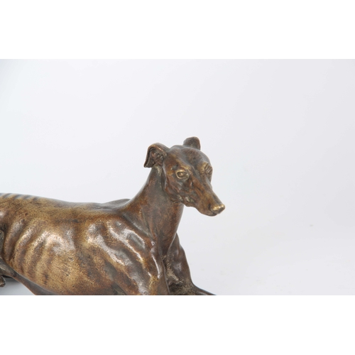 651 - A LATE 19th CENTURY PATINATED BRONZE SCULPTURE modelled as a recumbent greyhound 26cm long