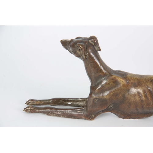 651 - A LATE 19th CENTURY PATINATED BRONZE SCULPTURE modelled as a recumbent greyhound 26cm long