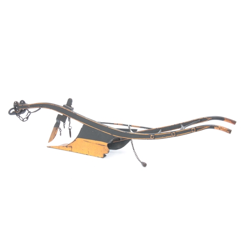 653 - A LATE 19th CENTURY CAST IRON MODEL OF A HORSE DRAWN PLOUGH in black and gold paint 54cm overall