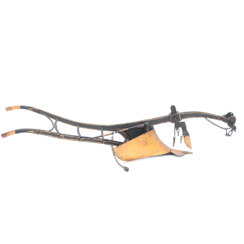 653 - A LATE 19th CENTURY CAST IRON MODEL OF A HORSE DRAWN PLOUGH in black and gold paint 54cm overall