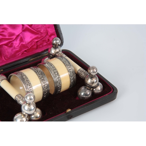 682 - A CASED SET OF IVORY AND WHITE METAL NAPKIN RINGS AND KNIFE RACK with silk lining case bearing maker... 