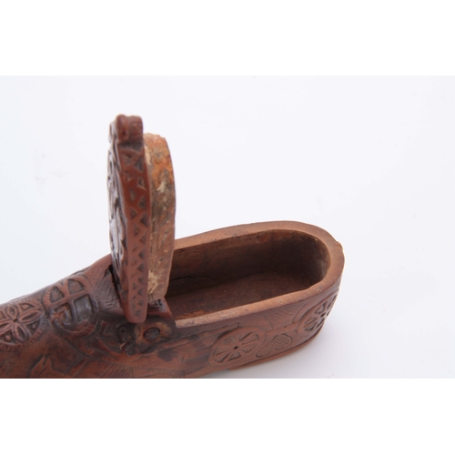 697 - AN EARLY 19TH CENTURY CARVED BOXWOOD FOLK ART SNUFF BOX IN THE SHAPE OF A SHOE decorated with figure... 