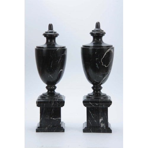 704 - A PAIR OF 20TH CENTURY  BLACK VEINED MARBLE URNS with shaped tops and plinth bases 48cm high.