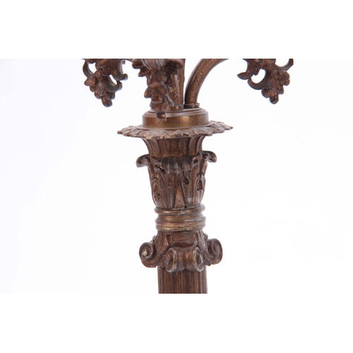 713 - A PAIR OF REGENCY STYLE FOUR BRANCH BRASS CANDELABRA with reeded tapering columns mounted on a shape... 