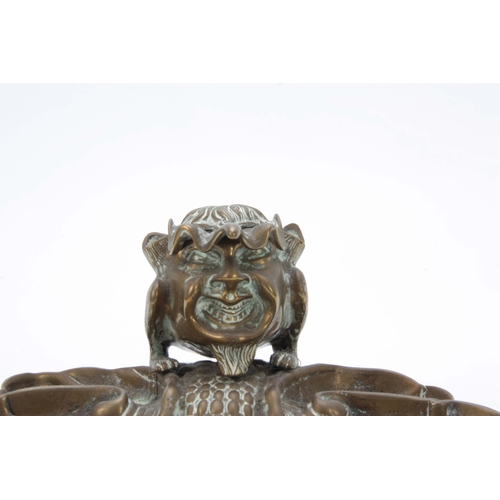 727 - A LATE 19th CENTURY NOVELTY BRASS DESK STAND the inkwell formed as a devil imp with hinged lid openi... 