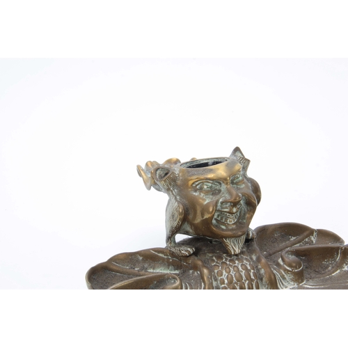 727 - A LATE 19th CENTURY NOVELTY BRASS DESK STAND the inkwell formed as a devil imp with hinged lid openi... 