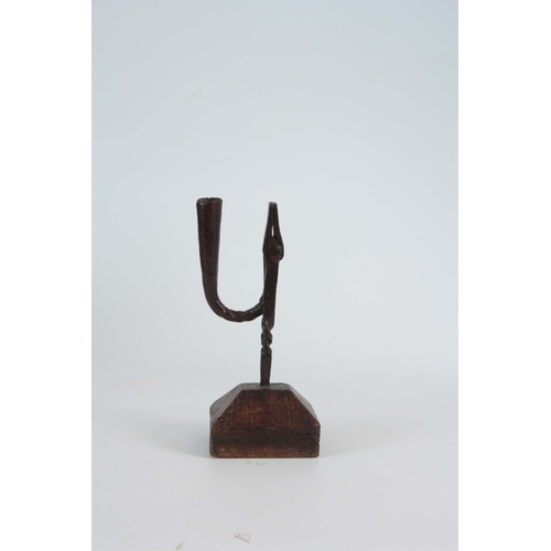 736 - AN EARLY 18th CENTURY RUSHLIGHT ON OAK BLOCK having a twisted stem design on chamfered rectangular b... 