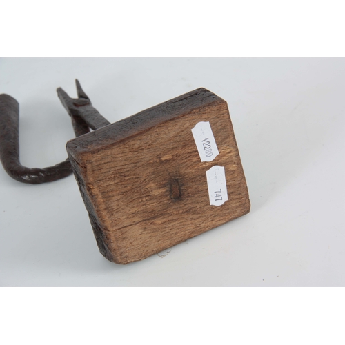 736 - AN EARLY 18th CENTURY RUSHLIGHT ON OAK BLOCK having a twisted stem design on chamfered rectangular b... 