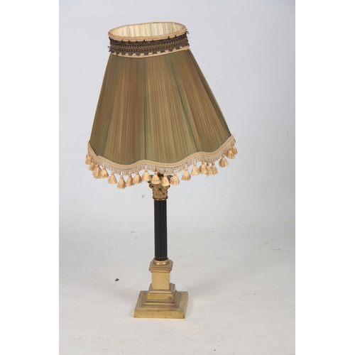 743 - A BRASS CORINTHIAN COLUMN ELECTRIFIED TABLE LAMP with reeded ebonized stem ad green pleated green sh... 