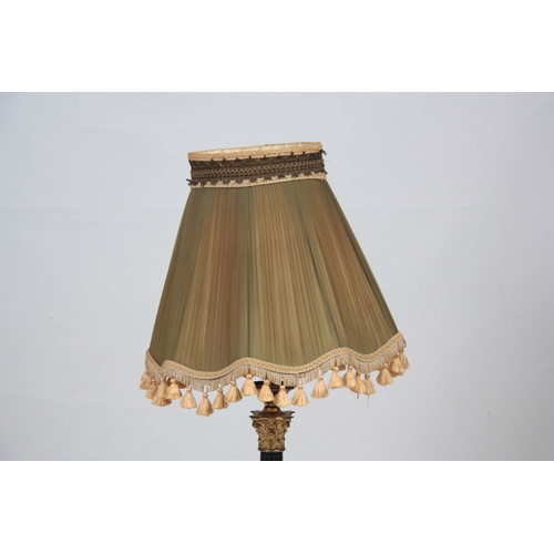 743 - A BRASS CORINTHIAN COLUMN ELECTRIFIED TABLE LAMP with reeded ebonized stem ad green pleated green sh... 