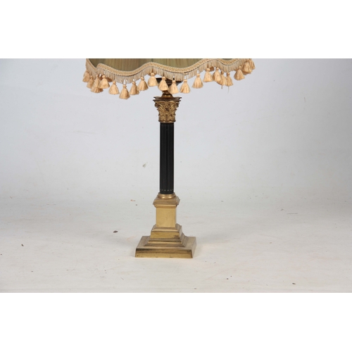 743 - A BRASS CORINTHIAN COLUMN ELECTRIFIED TABLE LAMP with reeded ebonized stem ad green pleated green sh... 