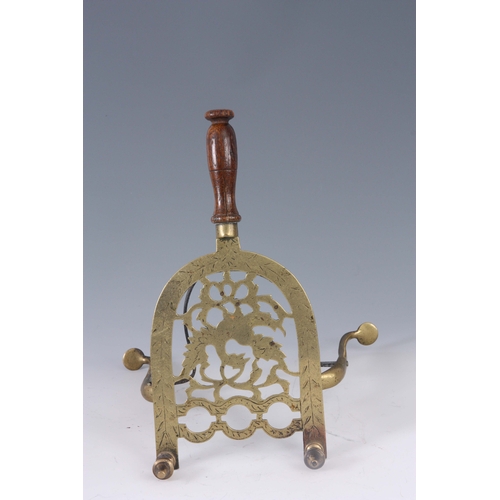 749 - A LATE GEORGIAN ENGRAVED BRASS HEARTH STAND with horseshoe-shaped cut-out top, centre bird moti... 