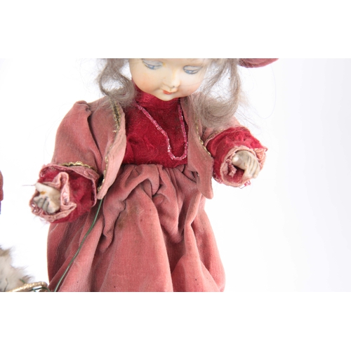 762 - AN EARLY 20TH CENTURY MUSICAL AUTOMATON OF A GIRL PLAYING WITH A CAT the girl having a bisque porcel... 