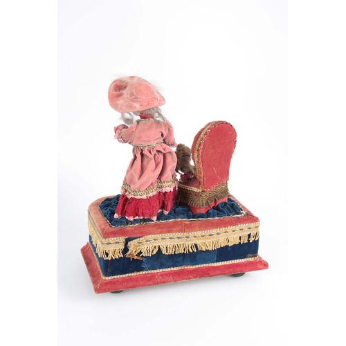 762 - AN EARLY 20TH CENTURY MUSICAL AUTOMATON OF A GIRL PLAYING WITH A CAT the girl having a bisque porcel... 