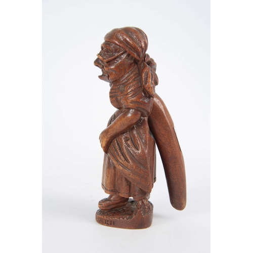 869 - A LATE 19TH CENTURY SWISS BLACK FOREST NUTCRACKER formed as an old woman with headscarf and glasses,... 