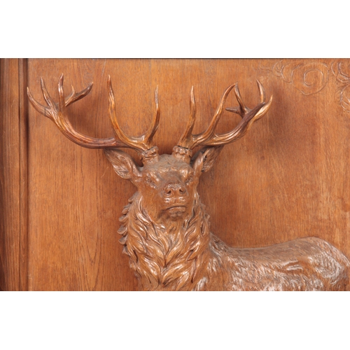 874 - A LATE 19TH CENTURY SWISS BLACK FOREST CARVED WALL PLAQUE depicting an imperial stag, surrounded by ... 