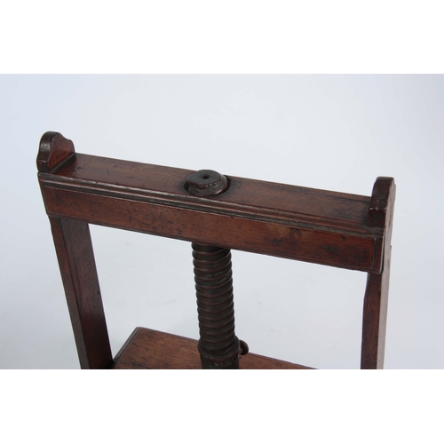 940 - AN 18TH CENTURY MAHOGANY BOOK PRESS of small proportions with central screw mechanism on raised feet... 