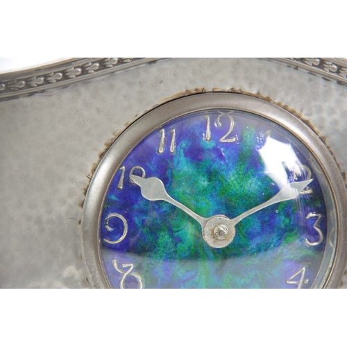 948 - AN EARLY 20TH CENTURY ARTS AND CRAFTS HAMMERED PEWTER MANTEL CLOCK WITH RUSKIN DIAL having Arabic nu... 