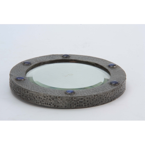 950 - AN ARTS AND CRAFTS HAMMERED PEWTER CIRCULAR MIRROR with blue Ruskin roundels and bevelled mirror pla... 