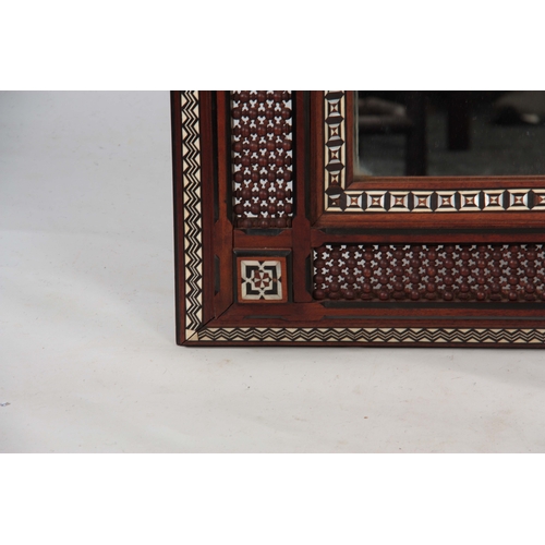 957 - AN EARLY 20TH CENTURY LIBERTY STYLE MAHOGANY MOORISH INLAID AND TURNED FRAMED MIRROR decorated with ... 