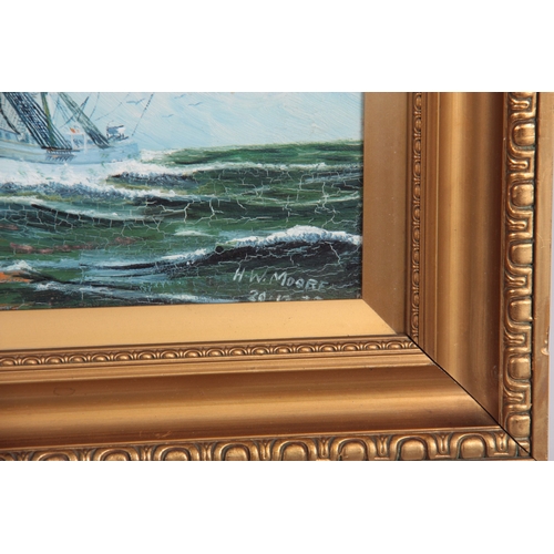 837 - H W MOORE OIL ON BOARD depicting two galleons in full sail - signed dated 1935, mounted in a glazed ... 