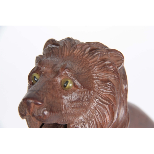 870 - A 19TH CENTURY BLACK FOREST NUTCRACKER IN THE FORM OF A LIONS HEAD with glass eyes 21cm long 9cm wid... 