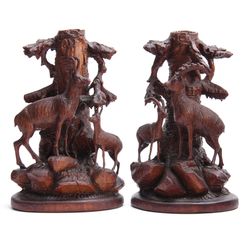 872 - A PAIR OF LATE 19TH CENTURY SWISS CARVED CANDLESTICKS with mountain goats beneath tree trunks on roc... 