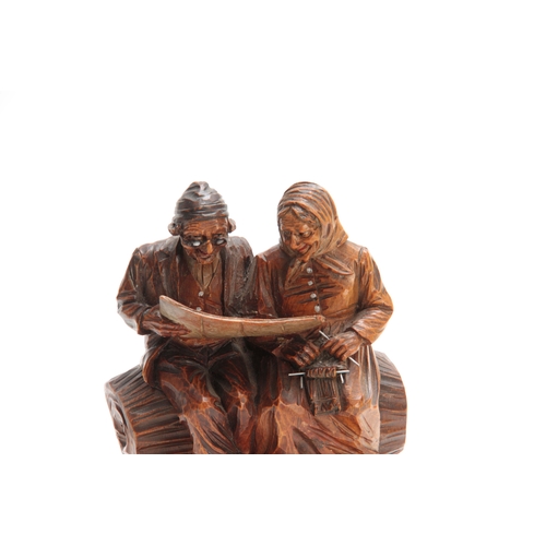 878 - A CONTINENTAL POLYCHROME CARVED FIGURE GROUP depicting a couple seated on a log 15cm wide 19cm high