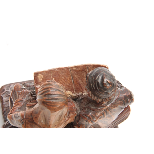 878 - A CONTINENTAL POLYCHROME CARVED FIGURE GROUP depicting a couple seated on a log 15cm wide 19cm high