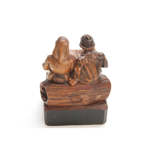 878 - A CONTINENTAL POLYCHROME CARVED FIGURE GROUP depicting a couple seated on a log 15cm wide 19cm high