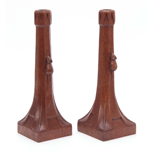 882 - A PAIR OF EARLY ROBERT MOUSEMAN THOMPSON OAK CANDLESTICKS with triangular carved sconces and facette... 