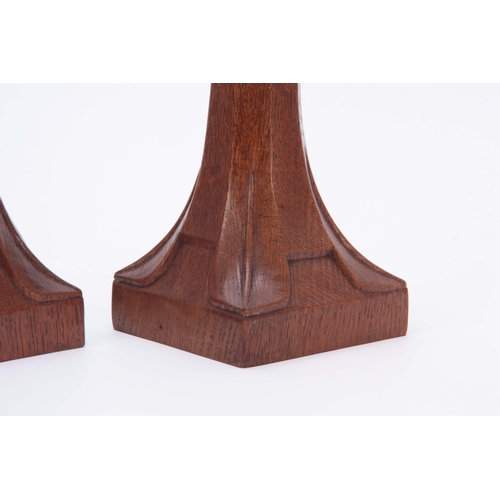 882 - A PAIR OF EARLY ROBERT MOUSEMAN THOMPSON OAK CANDLESTICKS with triangular carved sconces and facette... 