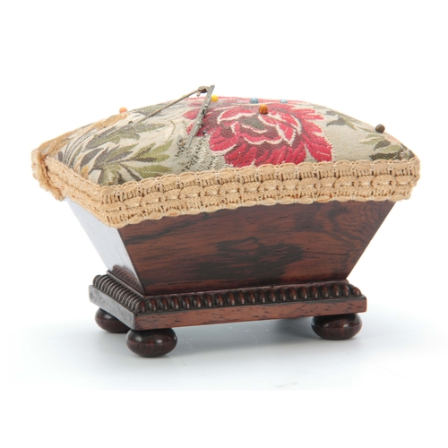 887 - AN EARLY VICTORIAN ROSEWOOD PIN CUSHION having chamfered sides and beaded moulding on bun feet 13.5c... 