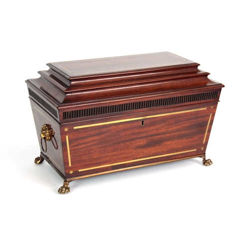 920 - A REGENCY BRASS INLAID MAHOGANY SARCOPHAGUS SHAPED TEA CADDY with reeded frieze and lions paw feet (... 