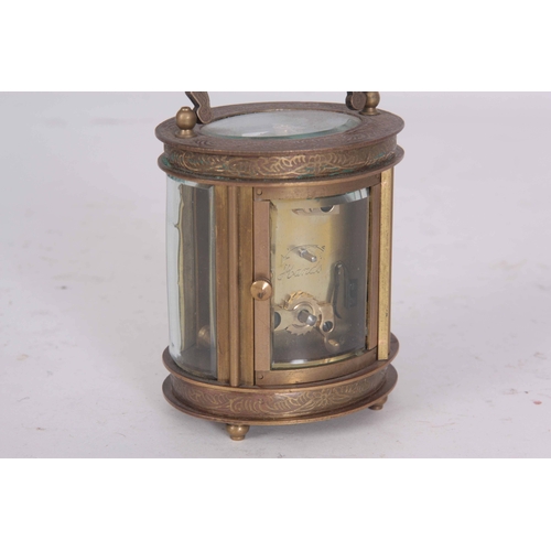 980 - A LATE 20th CENTURY OVAL CASED CARRIAGE CLOCK having chased scrollwork decoration enclosing a 40mm p... 