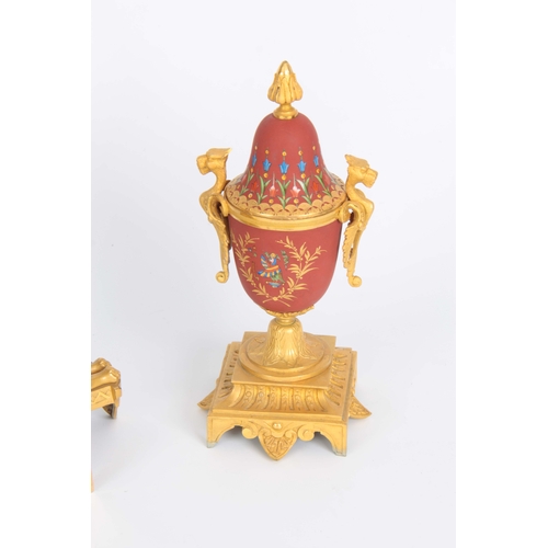 1091 - A LATE 19th CENTURY FRENCH EGYPTIAN STYLE ORMOLU AND PORCELAIN CLOCK GARNITURE the case surmounted b... 