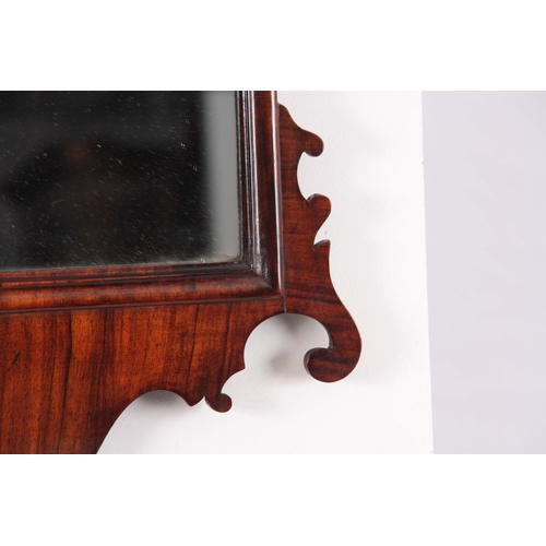 1113 - A 19TH CENTURY MAHOGANY FRET-CUT HANGING MIRROR having a rectangular mirror plate surrounded by an O... 