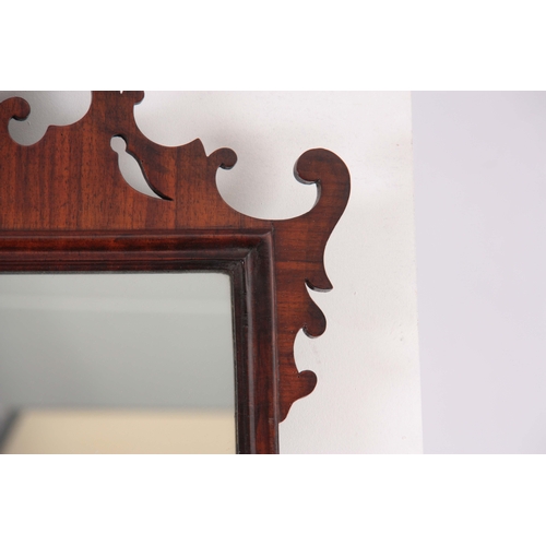 1113 - A 19TH CENTURY MAHOGANY FRET-CUT HANGING MIRROR having a rectangular mirror plate surrounded by an O... 