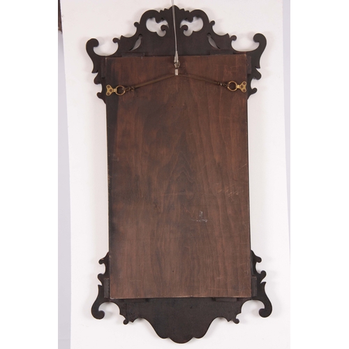 1113 - A 19TH CENTURY MAHOGANY FRET-CUT HANGING MIRROR having a rectangular mirror plate surrounded by an O... 